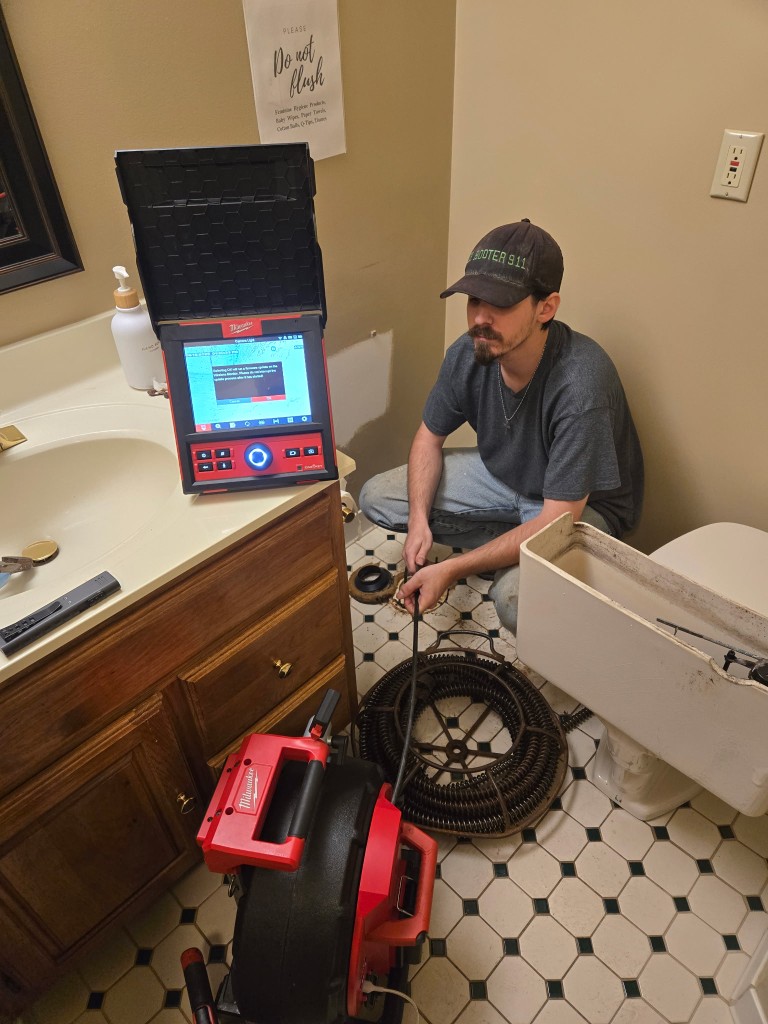 Doctor Rooter 911 technician performing a sewer camera inspection with Milwaukee camera equipment